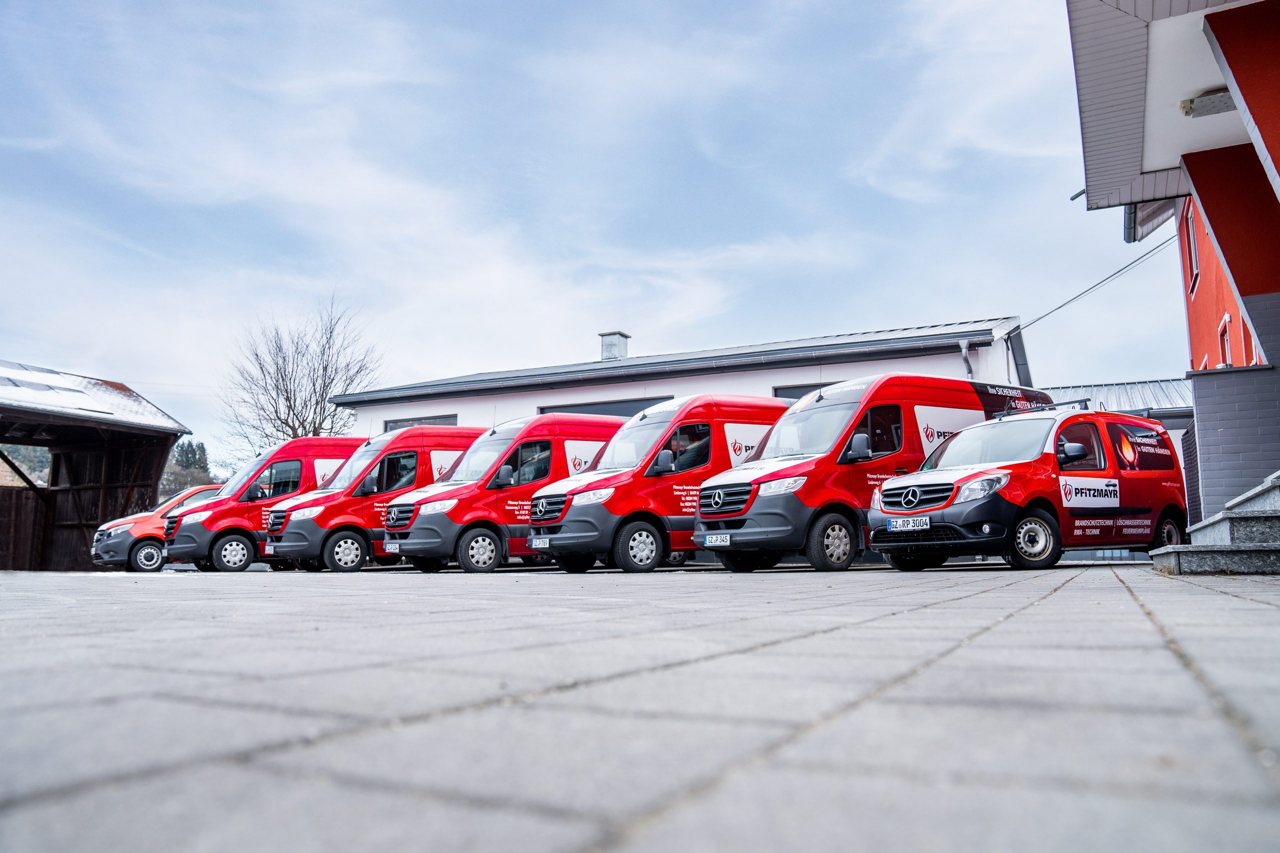 Roter Servicefuhrpark der Pfitzmayr Brandschutztechnik vor dem Firmensitz in Aichen